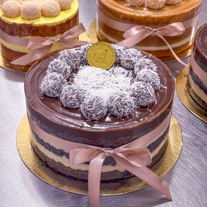 Bolo artesanal Doce Capricho, naked cake decorado com coco e laço